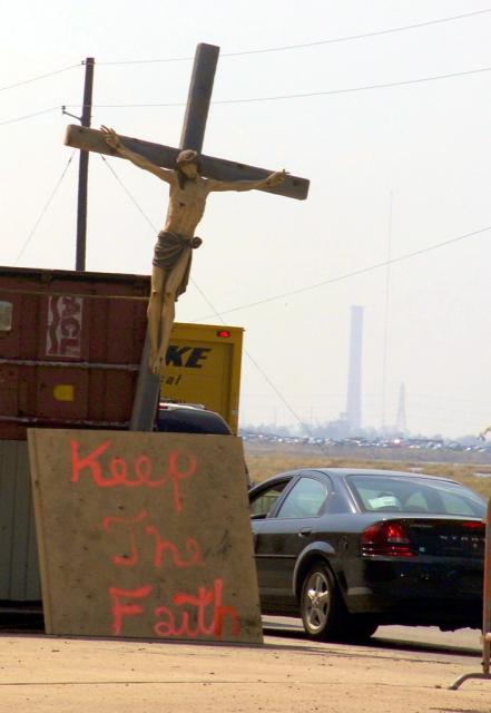  A Crucifix and a sign "Keep the Faith" greets residents and aid workers as they enter a National Guard Check point in Chalmette