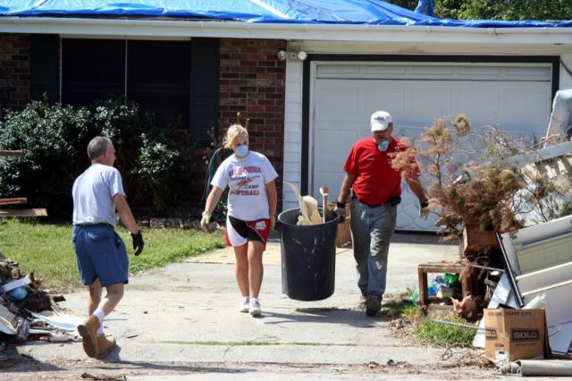 Rev Terry Collins and Jenna Brooks haul out debris from Roger and Ellen's home 