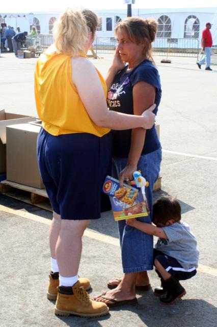 Team Member Kim Brown comforts Krystal (R) as her son clings to her leg 