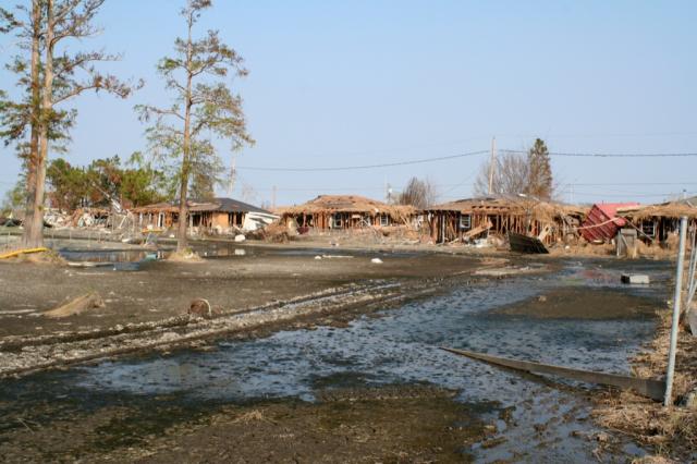 Homes completely destroyed in Chalmette… Note the sea grass on the roofs and the red container truck wedged between the houses.