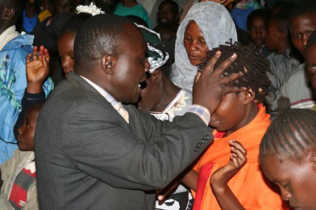  Pastor Solomon praying for the Mama at the Alter call during the Crusade 