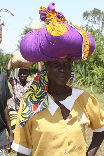 A woman of Homa-bay with her head scarf full of corn starts home 