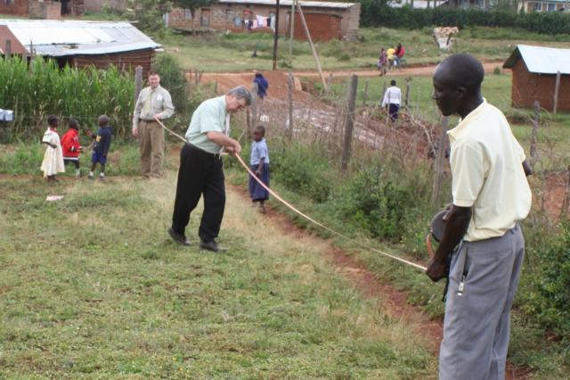 David Campbell, Pastor Terry, and Eric measure a possible site of an orphanage in Eldoret 