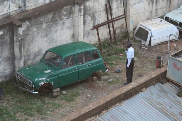 This man has just exit this car which is his home. He puts on his suit and brushes his teeth to start his day