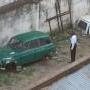 This man has just exit this car which is his home. He puts on his suit and brushes his teeth to start his day