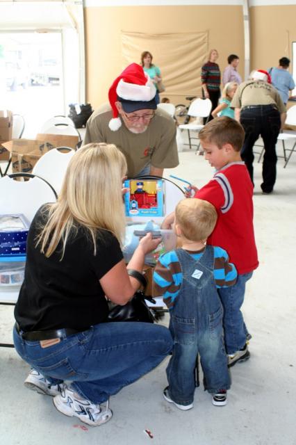 Team member Richard Schall (center) helps a family open their gifts. 