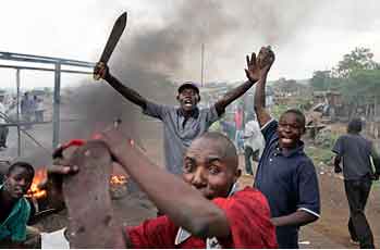 Luo tribe members armed with machetes and rocks enforce a makeshift roadblock, searching passing vehicles for Kikuyus trying to flee the town in order to kill them in Kisumu.