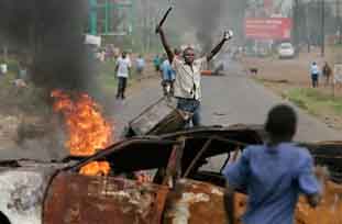 Kenyans, mainly from the Luo tribe, one armed with a machete, enforce a roadblock in Kisumu