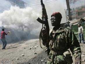 Member of Kenyan security forces patrols as fire guts a slum dwelling in Mathare, Nairobi